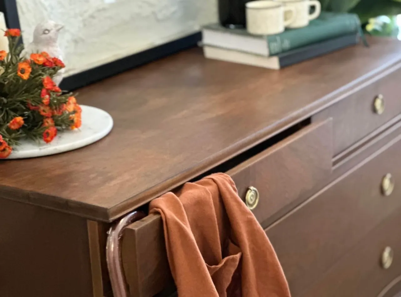 Hand-refinished dresser top styled with books and a linen throw